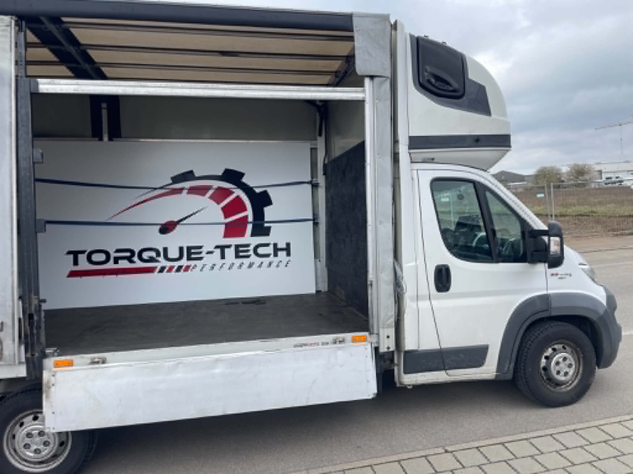 Transporter mit geöffneter Schiebeplane und leerem Laderaum